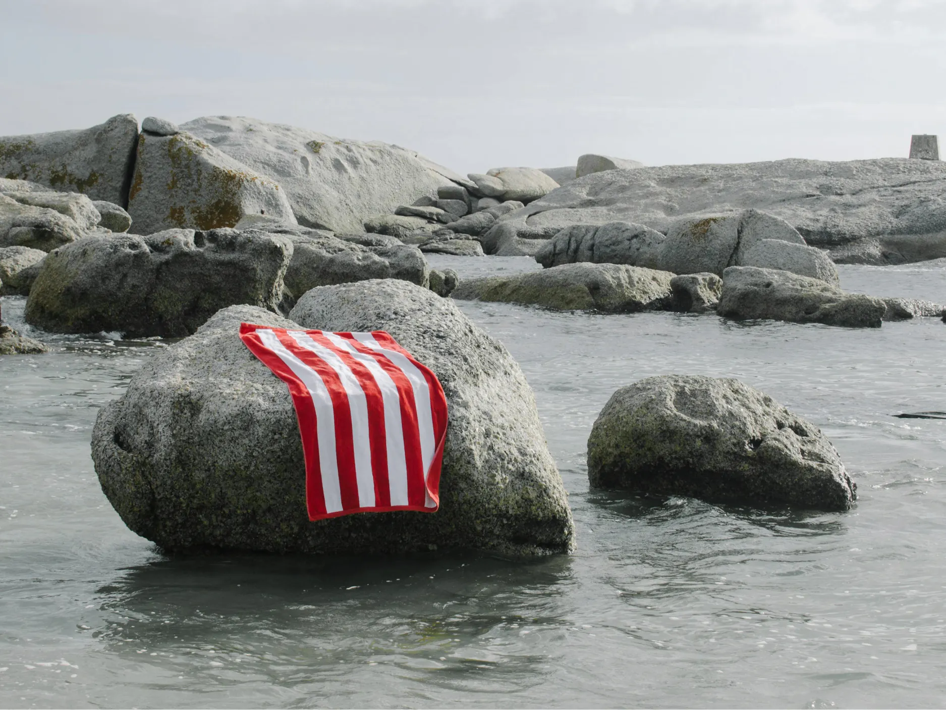 Rdeče-bela brisača na skali v morju